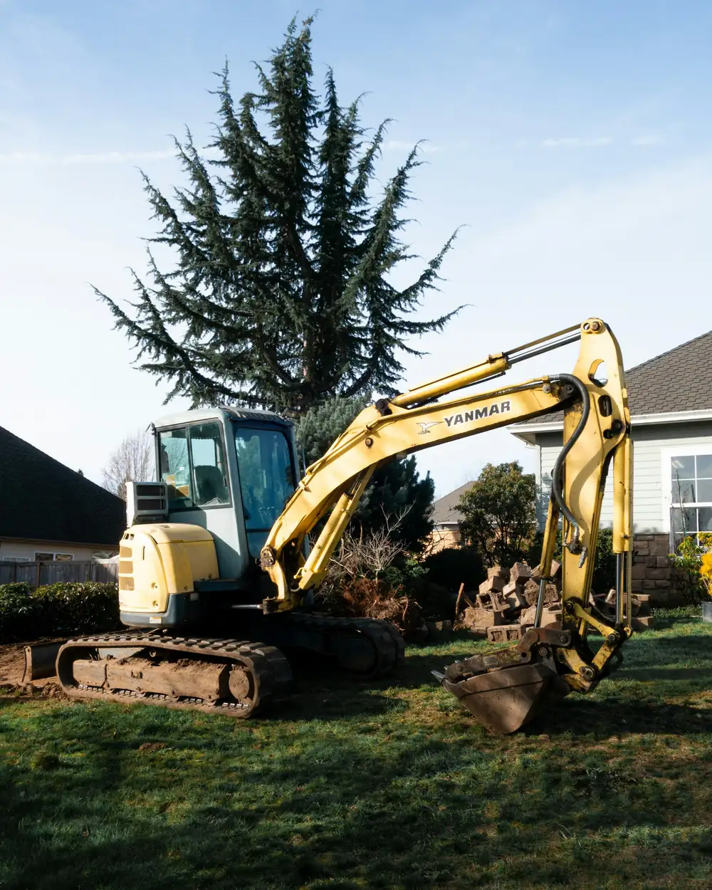Small excavator on a suburban lawn in afternoon light